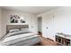 Cozy bedroom showcasing a comfortable bed, light walls, and refinished wood floors at 6220 W 11Th Pl, Lakewood, CO 80214