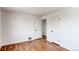 A bright bedroom featuring light walls, refinished wood floors, and open closet space at 6220 W 11Th Pl, Lakewood, CO 80214