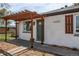 Inviting home exterior showcasing pergola, well-manicured lawn, and stylish front door at 6220 W 11Th Pl, Lakewood, CO 80214