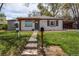 Attractive ranch-style home with white painted brick and a pergola covered porch at 6220 W 11Th Pl, Lakewood, CO 80214