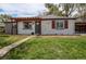 Charming home exterior with a well-manicured lawn, pergola, and brick facade at 6220 W 11Th Pl, Lakewood, CO 80214