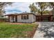 Charming exterior featuring a well-manicured lawn, carport, and brick facade at 6220 W 11Th Pl, Lakewood, CO 80214