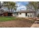 Exterior view of the house with a large yard and covered outdoor lounge area at 6220 W 11Th Pl, Lakewood, CO 80214