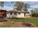 Exterior view of the house showing the covered outdoor lounge area and spacious yard at 6220 W 11Th Pl, Lakewood, CO 80214