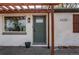Front entrance showcasing a light brick, modern shutters, green front door, and pergola covered entryway at 6220 W 11Th Pl, Lakewood, CO 80214