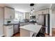 Modern kitchen with stainless steel appliances, white cabinetry, and breakfast bar at 6220 W 11Th Pl, Lakewood, CO 80214