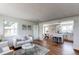 Open-concept living room with hardwood floors, white walls, and views into the modern kitchen and dining area at 6220 W 11Th Pl, Lakewood, CO 80214