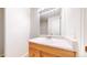 Bathroom vanity with a neutral countertop, light wood cabinets, and a bright mirror at 12327 E Tennessee Dr # 107, Aurora, CO 80012