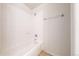 White tiled bathtub and shower with chrome hardware and tile surround at 12327 E Tennessee Dr # 107, Aurora, CO 80012