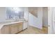 Traditional kitchen area featuring a white double basin sink, tiled flooring, and modern appliances at 12327 E Tennessee Dr # 107, Aurora, CO 80012