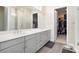 Stylish bathroom featuring double sinks, a large mirror, and access to a well-organized walk-in closet at 7242 Canyon Sky Trl, Castle Pines, CO 80108