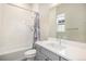 Well-lit bathroom featuring modern vanity, generous mirror, and tiled shower/tub at 7242 Canyon Sky Trl, Castle Pines, CO 80108