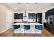 Bright kitchen featuring stainless steel appliances, island with breakfast bar, and modern pendant lighting at 7242 Canyon Sky Trl, Castle Pines, CO 80108