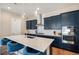 Well-lit kitchen with a large island, stainless steel appliances, and stylish blue accent chairs at 7242 Canyon Sky Trl, Castle Pines, CO 80108