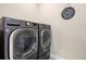 Modern laundry room with a front-loading washer and dryer at 7242 Canyon Sky Trl, Castle Pines, CO 80108