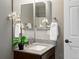 Bathroom vanity with granite countertop, decorative mirror, and white flower accent at 11082 Fillmore Way, Northglenn, CO 80233