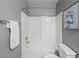 Bright bathroom with white tiled shower and tub combination, next to the toilet at 11082 Fillmore Way, Northglenn, CO 80233