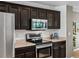 Kitchen showcasing dark wood cabinetry, stainless steel oven, and countertop appliances at 11082 Fillmore Way, Northglenn, CO 80233