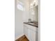 Elegant half bath with a modern vanity, stone countertop and decorative oval window at 1016 31St St, Denver, CO 80205