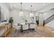 Elegant dining area with stylish lighting, a large table, and a view of the staircase at 1016 31St St, Denver, CO 80205