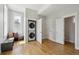 Bright laundry room with wood floors features stacked washer/dryer and a window seat with pillows at 1016 31St St, Denver, CO 80205