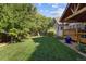 A lush green lawn surrounds a home with a covered patio at 6073 W Adriatic Pl, Lakewood, CO 80227