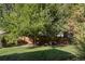 A lush backyard featuring mature trees, a well-maintained lawn, and a wooden fence at 6073 W Adriatic Pl, Lakewood, CO 80227