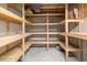 An unfinished basement with wooden shelving provides ample storage space at 6073 W Adriatic Pl, Lakewood, CO 80227