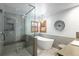 Elegant bathroom with a glass shower, soaking tub, and modern fixtures at 6073 W Adriatic Pl, Lakewood, CO 80227