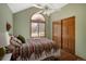 Bedroom features an arched window, ceiling fan, and closet, offering a comfortable and inviting space at 6073 W Adriatic Pl, Lakewood, CO 80227