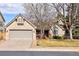 Charming brick home featuring mature trees, a two-car garage, and a well-maintained lawn at 6073 W Adriatic Pl, Lakewood, CO 80227