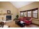 Spacious living room featuring a brick fireplace and large windows with window seats at 6073 W Adriatic Pl, Lakewood, CO 80227