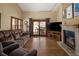 Inviting living room with hardwood floors, a fireplace, large windows, and patio access at 6073 W Adriatic Pl, Lakewood, CO 80227