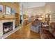 Cozy living room features a fireplace and open access to the adjacent kitchen and dining areas at 6073 W Adriatic Pl, Lakewood, CO 80227