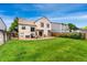 A spacious back yard featuring a grassy lawn and a concrete patio with an outdoor dining area and a grill at 7796 Xavier Ct, Westminster, CO 80030