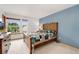 Spacious bedroom featuring natural light with a large bed and colorful quilt, complemented by blue accent wall at 7796 Xavier Ct, Westminster, CO 80030