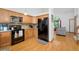 Modern kitchen with wood cabinets, stainless steel appliances, and an open layout connecting to the living area at 7796 Xavier Ct, Westminster, CO 80030