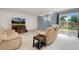 Cozy living room with large television, comfortable recliner, and a sliding glass door to the back yard at 7796 Xavier Ct, Westminster, CO 80030