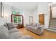Bright living room featuring hardwood floors, comfortable sofas, a large window, and stairs to the second floor at 7796 Xavier Ct, Westminster, CO 80030