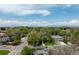 An aerial view of the neighborhood shows the city skyline and Rocky Mountains on a bright day at 301 Fairfax St, Denver, CO 80220