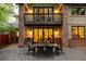The beautiful brick home has a backyard stone patio, an outdoor table, and a balcony above at 301 Fairfax St, Denver, CO 80220