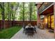 A well-maintained backyard offers a stone patio with an outdoor table and a view of the upper level balcony at 301 Fairfax St, Denver, CO 80220