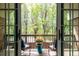 Charming balcony featuring two chairs and a table with a potted flower arrangement overlooking a lush green view at 301 Fairfax St, Denver, CO 80220