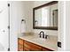 Bathroom with wood vanity, granite countertop, framed mirror, and modern black fixtures at 301 Fairfax St, Denver, CO 80220