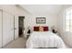 Bedroom featuring neutral carpet, a large window, and closet with white doors leading to a bath at 301 Fairfax St, Denver, CO 80220