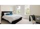 Bright bedroom featuring two large windows, a comfortable bed with blue pillows, and a workspace area at 301 Fairfax St, Denver, CO 80220