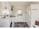 Spacious laundry room with washer, dryer, utility sink, storage cabinets, and access to the backyard at 301 Fairfax St, Denver, CO 80220