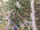 An aerial view shows a lovely home tucked among trees, close to the road and neighboring houses at 4515 Red Rock Dr, Larkspur, CO 80118