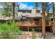 Backyard view features a wooden deck and surrounding greenery, offering a tranquil outdoor space at 4515 Red Rock Dr, Larkspur, CO 80118