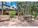Beautiful backyard patio with outdoor dining, fire pit, and lush landscaping, perfect for entertaining guests at 4515 Red Rock Dr, Larkspur, CO 80118